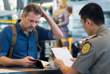 Traveler showing passport to an immigration officer at an airport checkpoint