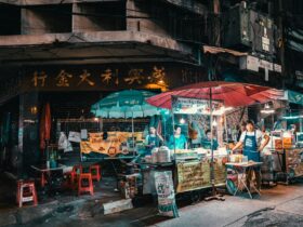 Colorful Thai night market with street food stalls, umbrellas, and vendors at night in an urban setting